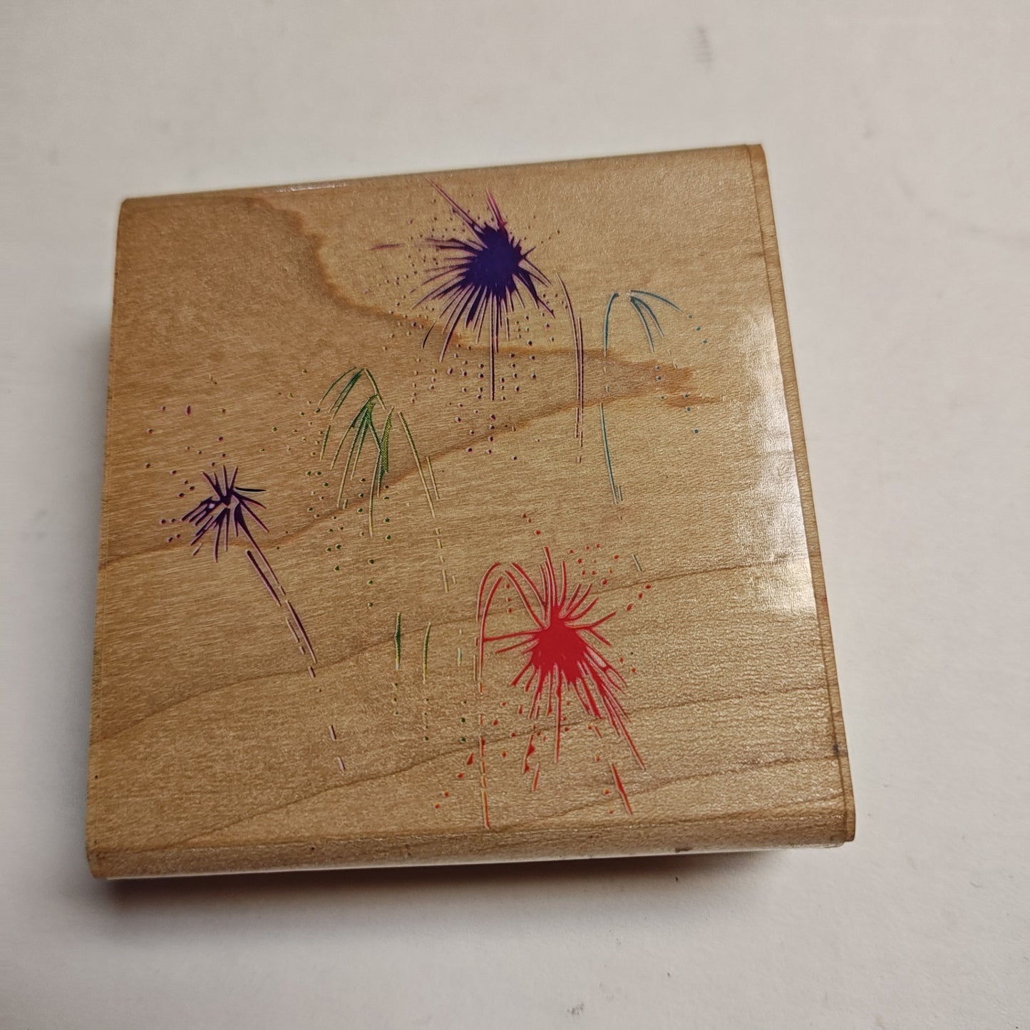 Rubber Stamp - Natural wood tone with colorful fireworks design (purple, red, green, blue) - 3"x3.25"